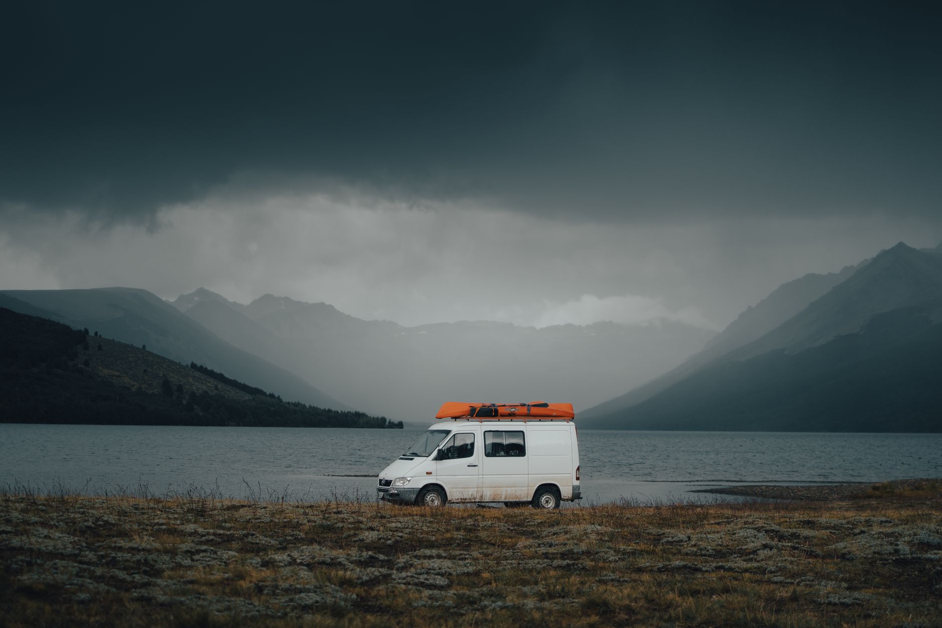 Campervan parked next to turquoise New Zealand lake